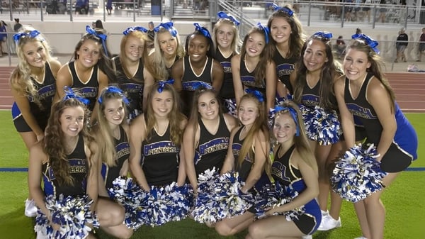 Eine Gruppe Cheerleader der Lafayette Christian Academy posiert gemeinsam in einheitlichen Uniformen auf einem Sportfeld.