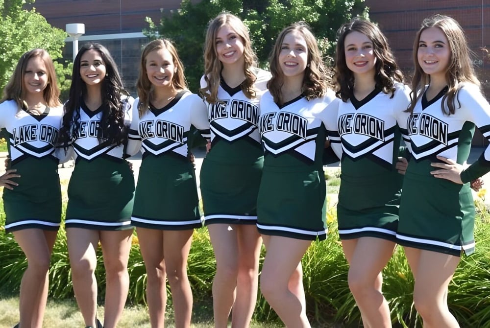 Eine Gruppe von jungen Cheerleaderinnen posiert im Freien auf dem Gelände der Lake Orion High School.
