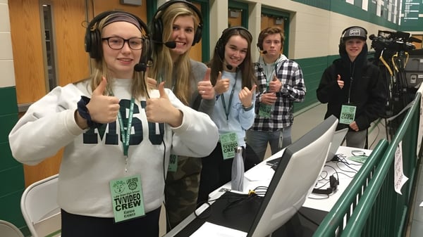 Schüler der Lake Orion High School stehen im Flur mit grünen Wänden und Schließfächern.