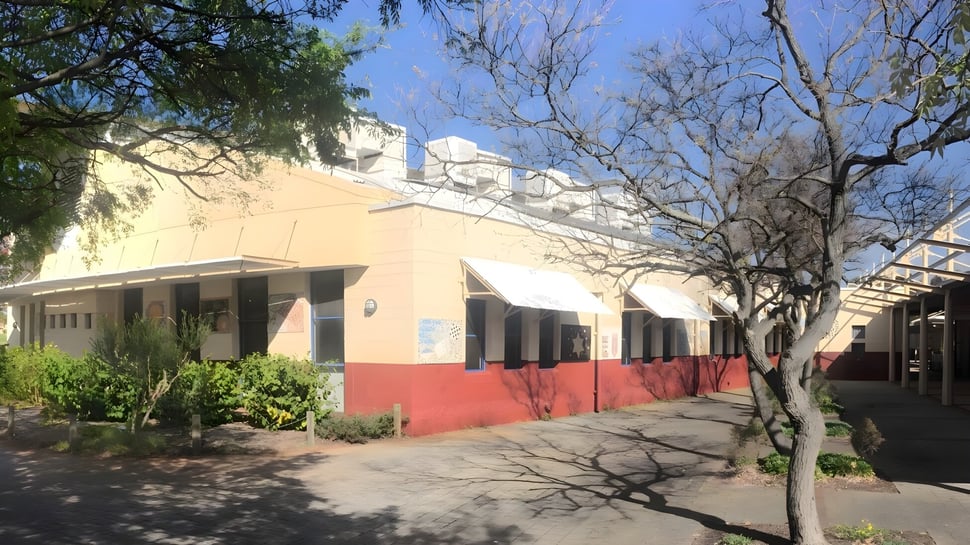 Das bunte zweifarbige Gebäude der Lakeland Senior High School ist von Bäumen umgeben und steht an einem gepflasterten Weg.