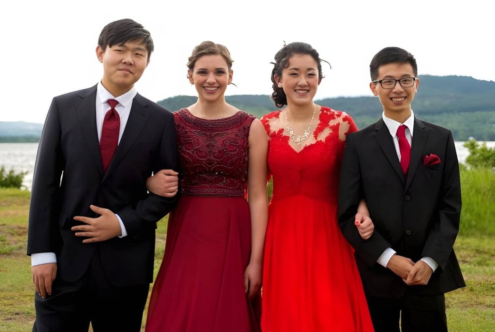 Vier Personen stehen vor einem See und Bergen auf dem Gelände der Lakes District Secondary School.