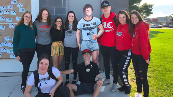 Eine Gruppe von Schülerinnen und Schülern steht vor dem Gebäude der Lambton Central Collegiate & Vocational School und posiert für ein Foto.