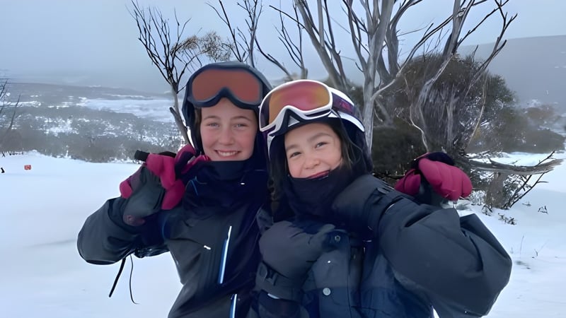 Eine Frau und ein Kind stehen in warmer Winterkleidung in einem verschneiten Wald auf dem Gelände der Lambton High School.