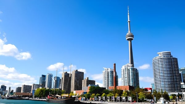 Eine moderne Stadtsilhouette mit hohen Wolkenkratzern und Fernsehturm vor blauem Himmel nahe dem L'Amoreaux Collegiate Institute.
