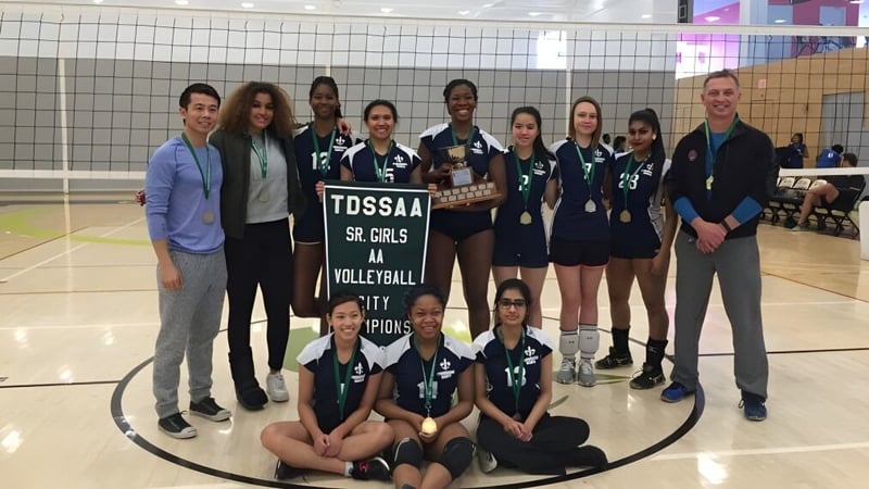 Schülerinnen des L'Amoreaux Collegiate Institute posieren mit Pokal auf dem Volleyballfeld als TDSAA Sr. Girls Volleyball Champions.