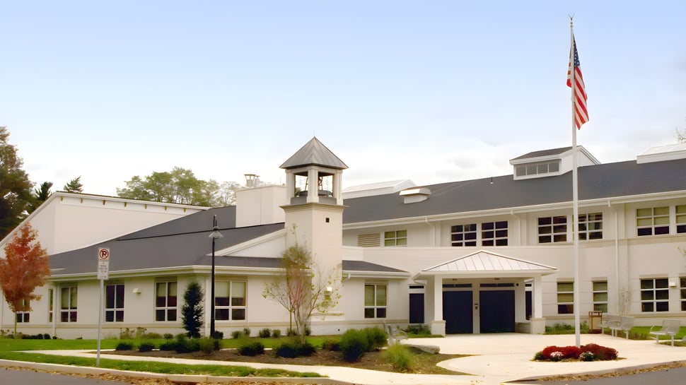 Das Gebäude der Lancaster Country Day School mit Glockenturm steht auf dem gepflegten Schulgelände unter einer amerikanischen Flagge.