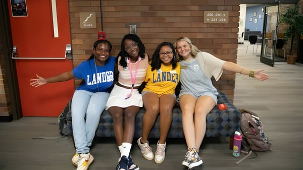 Eine Gruppe von vier Schülerinnen steht zusammen und lächelt auf dem Campus der Lander University.