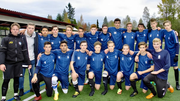 Eine Gruppe weiblicher Schülerinnen der Langley Fundamental Middle and Secondary School posiert gemeinsam in blauen Trikots auf einem Spielfeld.