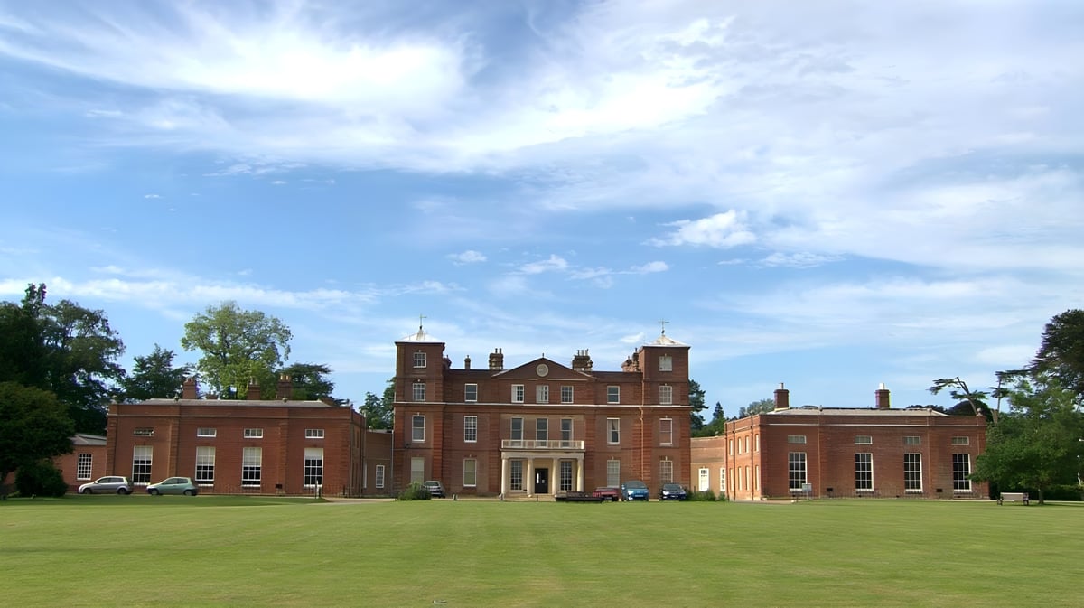 Das rote Backsteingebäude der Langley School steht vor blauem Himmel und ist von einem grünen Rasen umgeben.