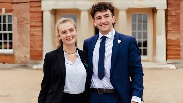 Ein junges Paar steht vor einem Backsteingebäude auf dem Campus der Langley School.