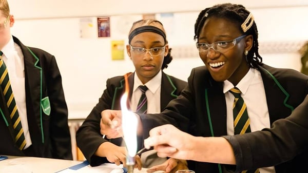 Drei Schülerinnen und Schüler der Langley School sitzen zusammen an einem Tisch und führen eine Diskussion.