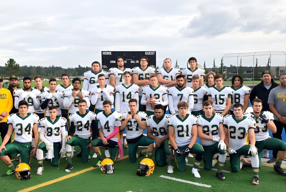 Schülerinnen und Schüler der Langley Secondary School posieren gemeinsam auf dem Sportfeld vor der Anzeigetafel.