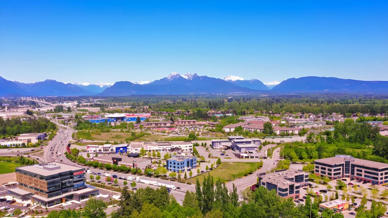 Die Berglandschaft mit einer Stadt im Vordergrund zeigt die Umgebung der Langley Fundamental Middle and Secondary School.