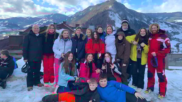 Eine Gruppe Schüler der Larkmead School posiert vor einer beeindruckenden schneebedeckten Bergkulisse.