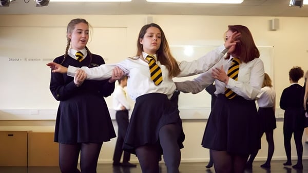 Drei Schülerinnen der Larkmead School stehen in ihren Schuluniformen im Schulflur zusammen.