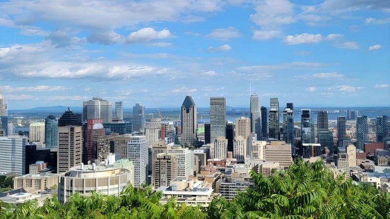Der lebendige Stadtblick mit Wolkenkratzern und Grünflächen vor blauem Himmel in der Nähe des LaSalle College Montreal.