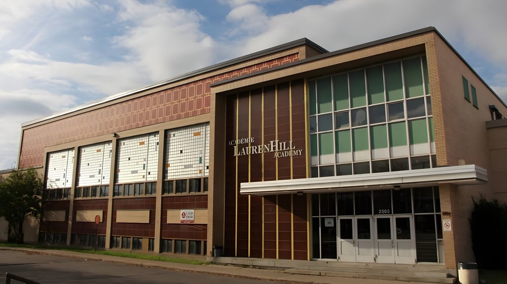 Das große Backsteingebäude der LaurenHill Academy steht vor einem bewölkten Himmel.
