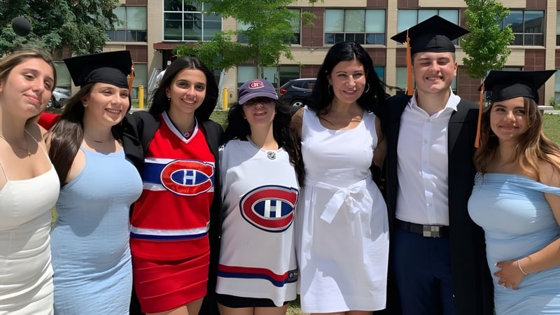 Eine Gruppe von Schülerinnen und Schülern der LaurenHill Academy in Abschlusskleidung und Hockeytrikots steht vor einem Gebäude mit Bäumen.