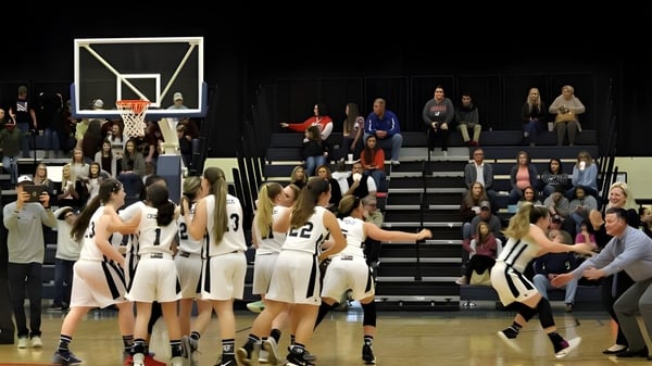 Schüler spielen ein Basketballspiel auf dem Spielfeld der Laurens Academy vor Zuschauern auf den Tribünen.