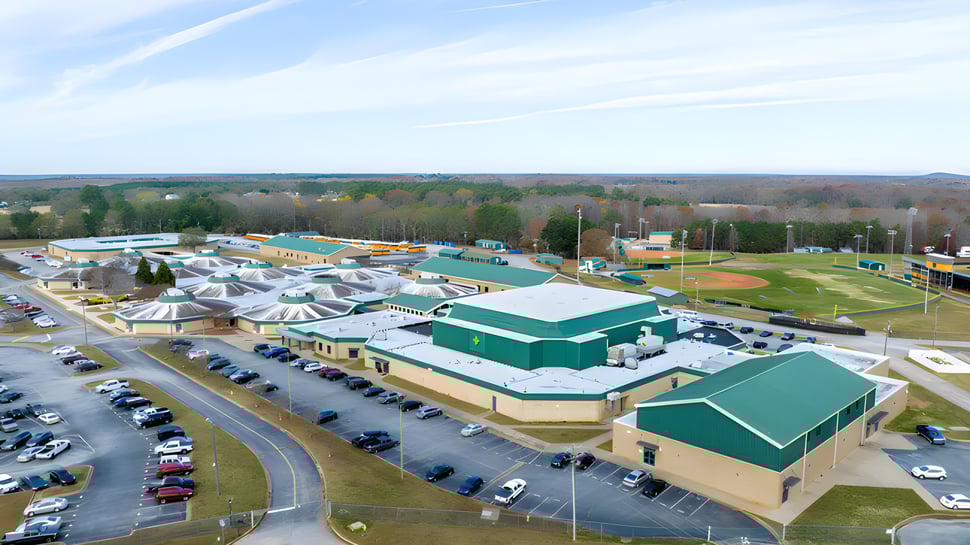 Luftaufnahme des großen Sportkomplexes auf dem Gelände der Laurens Academy mit Baseballfeldern und Schwimmbädern.