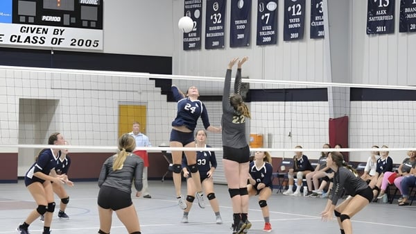 Schüler der Laurens Academy spielen ein Volleyballspiel in einer Sporthalle mit Bannern der Klasse 2005.