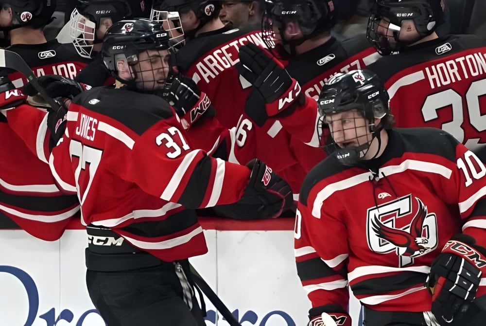 Eine Gruppe von Hockeyspielern in roten Trikots spielt auf dem Eis auf dem Gelände der Laurier MacDonald High School.
