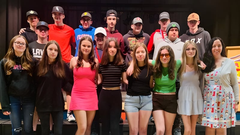 Eine Gruppe von Schülerinnen und Schülern steht gemeinsam auf einer Bühne auf dem Campus der Laval High School.