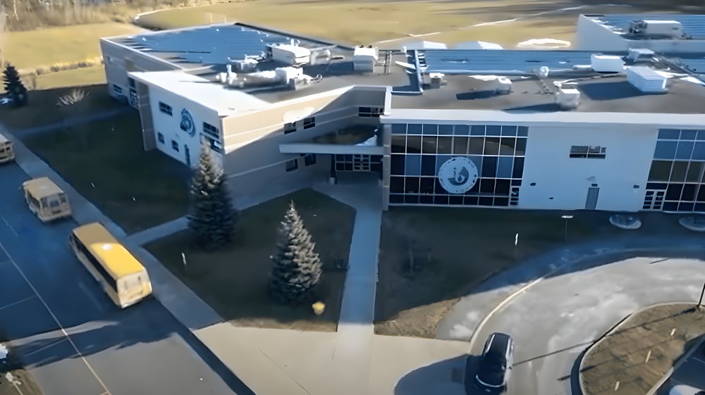 Das mehrstöckige Gebäude mit Uhrturm der École secondaire publique Le Sommet ist von Schnee umgeben.