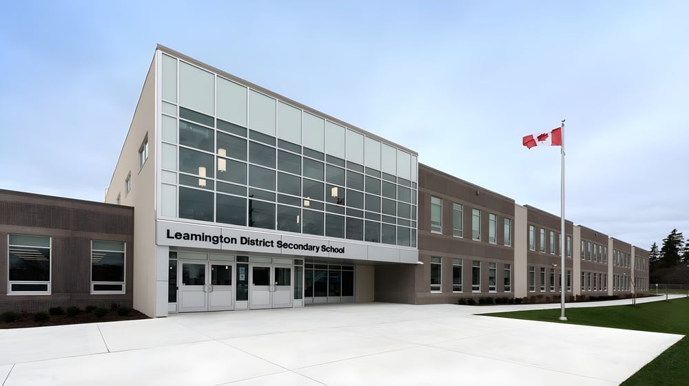 Das moderne Schulgebäude der Leamington District Secondary School mit kanadischer Flagge und angelegtem Außenbereich.