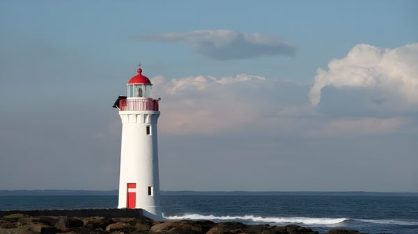 Ein weißer Leuchtturm mit roter Spitze steht an der felsigen Küste auf dem Gelände der Leeming Senior High School.