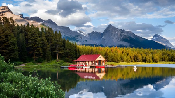 Ein rotes Bootshaus auf einem See vor einer Bergkulisse auf dem Gelände der Lester B. Pearson Catholic High School.