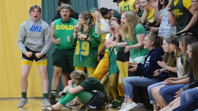 Schülerinnen und Schüler des Lethbridge Collegiate Institute jubeln in der Sporthalle während eines Spiels.