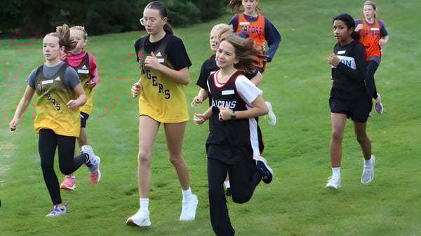 Junge Athletinnen laufen gemeinsam auf einem Feld auf dem Campus der Lethbridge School Division.