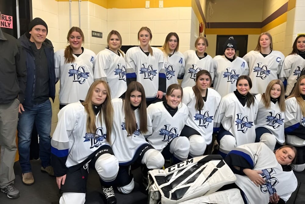 Eine Gruppe von Schülerinnen des Lewisporte Collegiate posiert in Hockeyausrüstung gemeinsam im Umkleideraum.