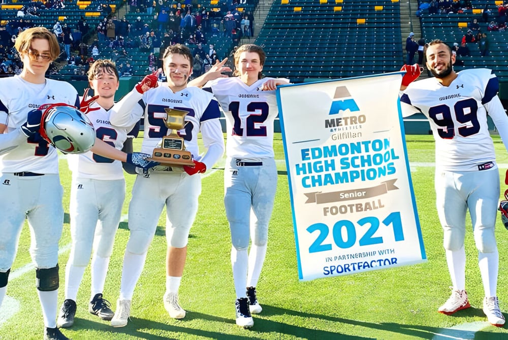 Schüler der Lillian Osborne High School stehen auf dem Sportplatz und halten ein Banner für die Football-Champions 2021.