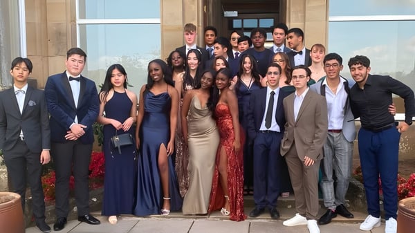 Eine Gruppe von Personen posiert vor dem großen Gebäude der Lime House School.