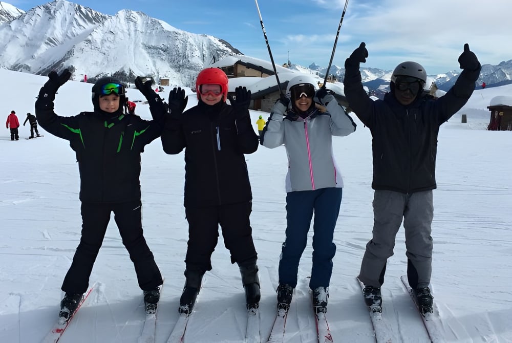 Eine Gruppe von Schülerinnen und Schülern der Lime House School steht mit Ski in einer verschneiten Berglandschaft.