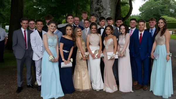 Eine Gruppe von Schülern der Lincoln Minster School versammelt sich draußen vor Bäumen und Grünflächen.