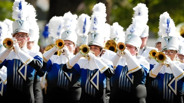 Die Marching Band des Lisgar Collegiate Institute spielt im Freien vor grünem Hintergrund.
