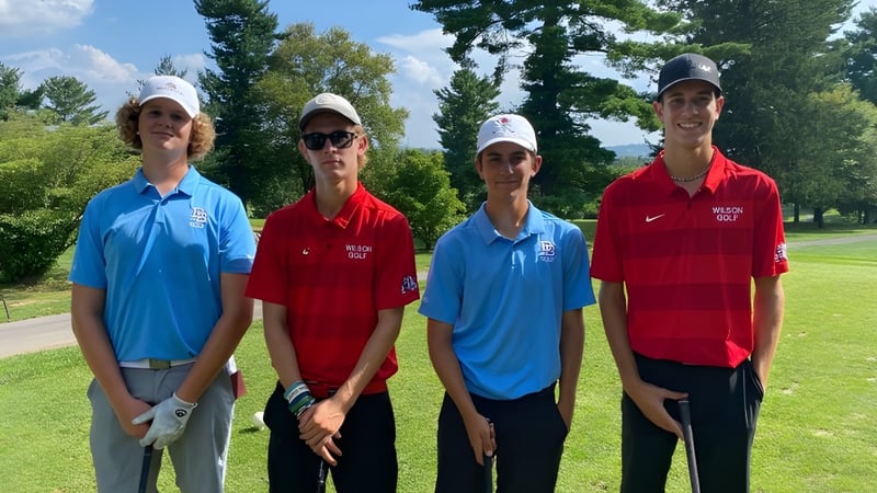 Vier Schülerinnen und Schüler des Listowel District Secondary School stehen auf einem Sportplatz im Freien.