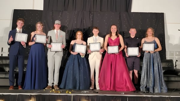 Schüler der Lomond Community School stehen auf der Bühne und halten Auszeichnungen vor einem Sternenhimmel.