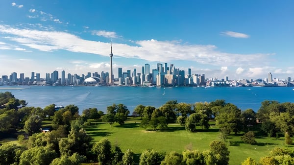 Grüne Parklandschaft vor der Skyline der Stadt mit blauem Himmel auf dem Gelände der London Central Secondary School.