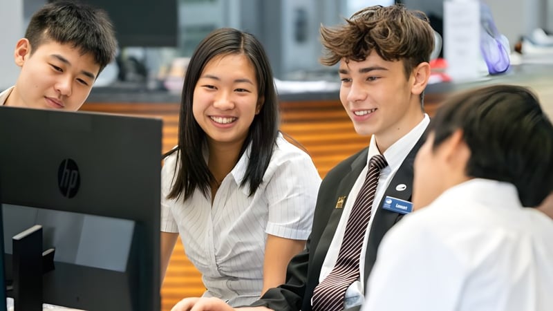 Schüler des Long Bay College arbeiten gemeinsam an einem Computer in einer Lernumgebung.