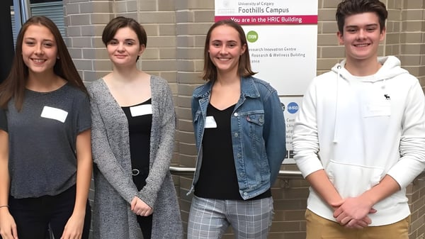 Vier Schülerinnen und Schüler stehen vor dem Gebäude mit dem Schild Facilities Campus auf dem Campus der Lord Beaverbrook High School.
