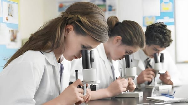 Schüler der Lord Tweedsmuir Secondary School arbeiten konzentriert mit Mikroskopen im naturwissenschaftlichen Unterricht.