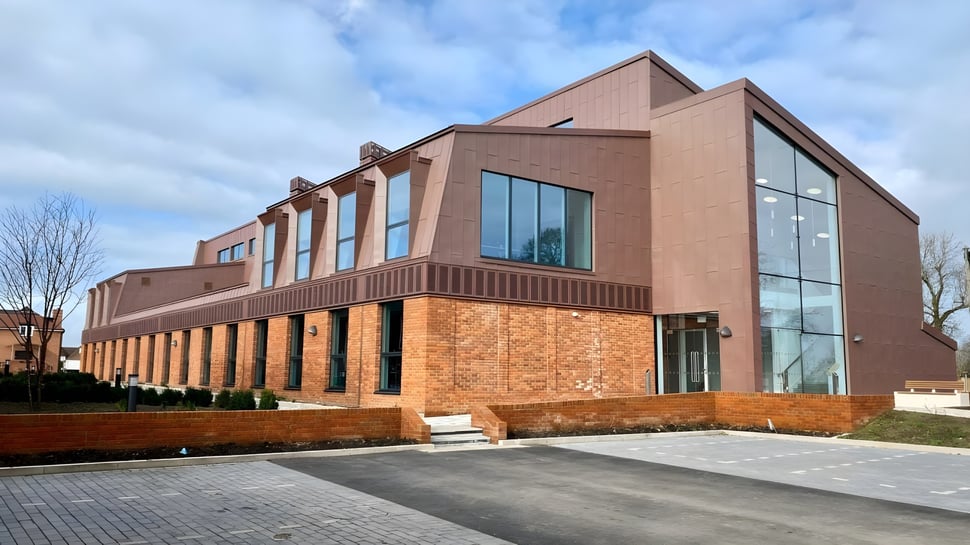 Das moderne mehrstöckige Gebäude des Lord Wandsworth College mit Backstein- und Glasfassade an einem bewölkten Tag.