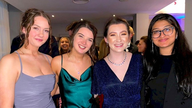 Vier junge Frauen in formeller Kleidung posieren gemeinsam auf dem Campus des Loreto College, St. Stephen's Green.