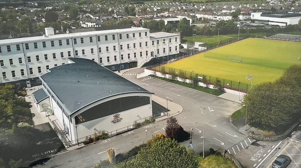 Das Hauptgebäude des Loreto College Mullingar mit einem geschwungenen Dach steht vor einem Grasfeld.