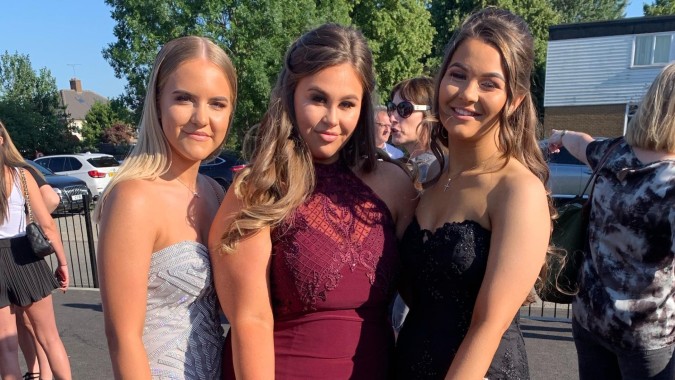 Drei Schülerinnen der Loreto High School Beaufort posieren gemeinsam im Freien vor Bäumen und Gebäuden.