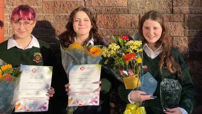 Drei Schülerinnen der Loreto Secondary School in Cork halten ihre Zertifikate und Blumen nach einer Abschlussfeier.